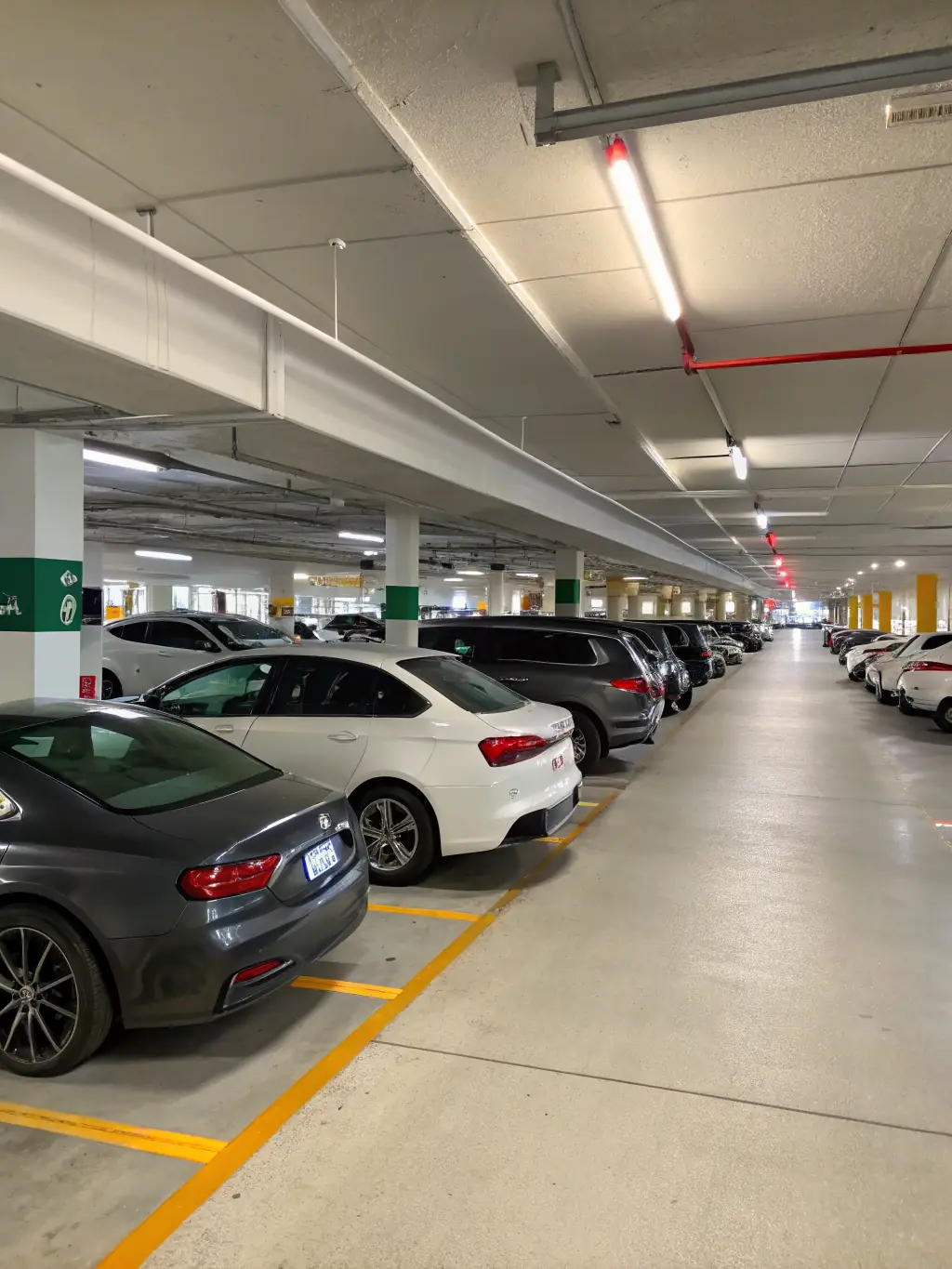 A photograph of the apartment building's secure parking garage, showcasing well-lit spaces and security cameras, emphasizing the safety and convenience for guests with vehicles.
